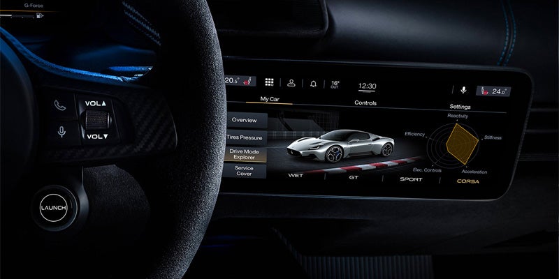 Interior of a car showing a digital dashboard displaying car settings, including a mode called 'Corsa.'